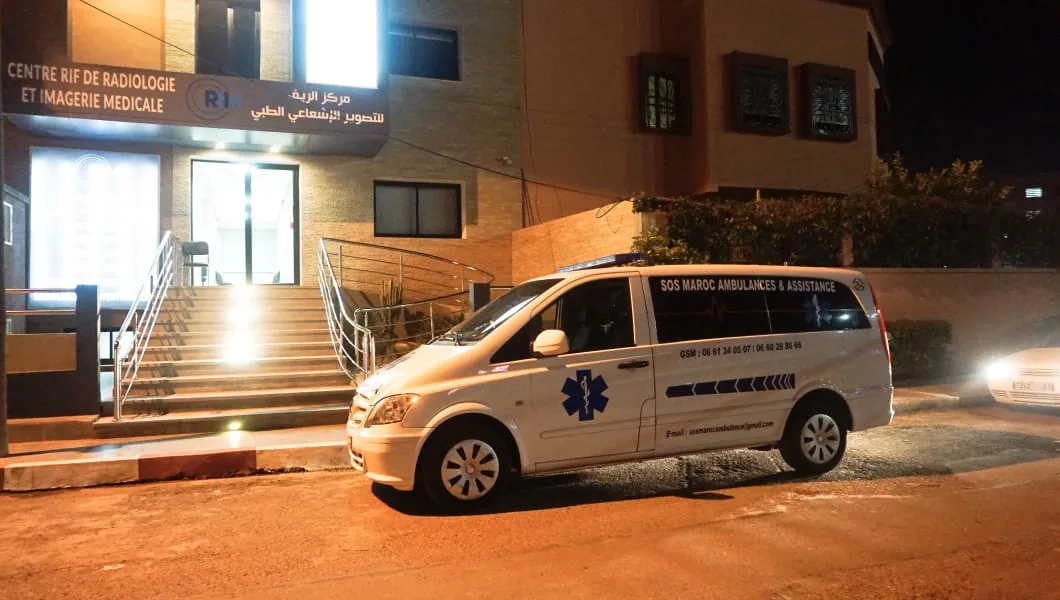 Transfert vers centre de radiologie et soins — Ambulance devant un centre d’imagerie médicale pour transfert patient, rendez-vous médical, retour à domicile ou assistance après examen.